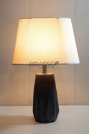 Modern black resin table lamp with elegant silhouette and fabric shade, creating warm ambient lighting for bedrooms, living rooms, and contemporary interiors.