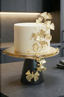 Black and gold cake tray displayed on a luxury marble dining table with elegant tableware.