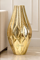 Golden lined metal vase displayed on a marble console table in a sophisticated living room.