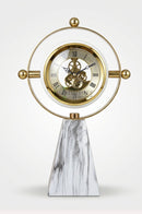 Golden metal table clock displayed on a marble console table in an elegant living room.