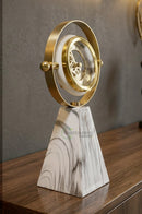 Golden table clock ornament arranged on a living room sideboard with modern decorative accents.