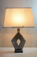 Modern grey X-shape fiber table lamp with beige fabric shade, providing warm ambient lighting for bedrooms, living rooms, and contemporary home interiors.