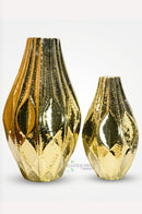 Large golden metal vase styled beside a contemporary entryway console for a luxurious look.