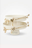 Off-white metal cake tray displayed on an elegant marble dining table with modern tableware.