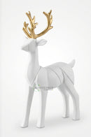 Standing and sitting white deer figurines arranged on a wooden bookshelf in an elegant home.