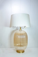 The lined glass surface creates a stunning interaction with light, producing subtle reflections and a warm golden ambiance that instantly elevates the atmosphere of any room.